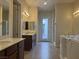 Bright bathroom with dual vanities, tile flooring, bathtub, and natural light at 7934 Cape Flattery Ave, Las Vegas, NV 89147