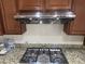 Kitchen features granite countertops, stainless steel range hood, and four-burner cooktop at 7934 Cape Flattery Ave, Las Vegas, NV 89147