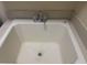Close up of a white laundry sink featuring a chrome faucet and utilitarian design at 7934 Cape Flattery Ave, Las Vegas, NV 89147