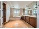 Bright bathroom with a round window above the soaking tub, a large vanity, and tile floors at 9101 Alta Dr # 1203, Las Vegas, NV 89145