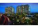 Luxury high-rise buildings with illuminated windows at dusk, surrounded by lush palm trees at 9101 Alta Dr # 1203, Las Vegas, NV 89145