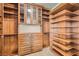 This walk-in closet has custom wood shelves, drawers, and cabinets for maximum storage at 9101 Alta Dr # 1203, Las Vegas, NV 89145