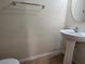 Small bathroom with a pedestal sink, round mirror, neutral walls, and tile flooring at 9312 Gold Dove Ct, Las Vegas, NV 89178