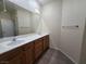 Well-lit bathroom with double sinks, wood cabinets, and a large mirror, offering a functional space at 9312 Gold Dove Ct, Las Vegas, NV 89178