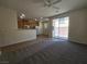 Open floor plan connecting living room to kitchen, featuring carpet, tile, and a sliding glass door at 9312 Gold Dove Ct, Las Vegas, NV 89178