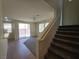 Bright living room area featuring stairs, tile flooring, neutral walls, carpet and access to the backyard at 9312 Gold Dove Ct, Las Vegas, NV 89178