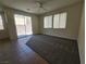 Bright living room with windows, carpet flooring, and sliding door access to the backyard at 9312 Gold Dove Ct, Las Vegas, NV 89178