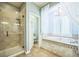Luxurious bathroom featuring a standalone tub, shower and tiled floors at 10373 Hawk Ravine St, Las Vegas, NV 89178