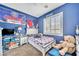 Nicely decorated bedroom features a twin bed, desk, and window with plantation shutters at 10373 Hawk Ravine St, Las Vegas, NV 89178
