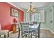 Formal dining room with large window, stylish chandelier, and seating for eight at 10373 Hawk Ravine St, Las Vegas, NV 89178