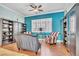 Comfortable living room with hardwood floors, bright, colorful walls, built in bookcases, and large window at 10373 Hawk Ravine St, Las Vegas, NV 89178