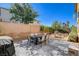 Private backyard with a stone-paved patio, dining table, chairs, BBQ, and garden at 1127 Lake Berryessa St, Henderson, NV 89002