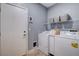 This laundry room features a washer, dryer, storage shelf, and door to the rest of the home at 1127 Lake Berryessa St, Henderson, NV 89002