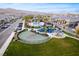 Scenic aerial view of a neighborhood featuring a playground, community pool, and green spaces at 12110 Midnight Pine Rd # 4, Las Vegas, NV 89183