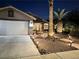 Inviting home exterior with desert landscaping, walkway lighting, and a two car garage at 1367 Sun Pillars Ave, Henderson, NV 89014
