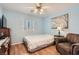 Cozy bedroom featuring wood floors, ceiling fan, and tranquil blue walls for a peaceful retreat at 1667 Sabatini Dr, Henderson, NV 89052