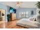 Open main bedroom with wood floors, large screen TV, and comfortable bed at 1667 Sabatini Dr, Henderson, NV 89052