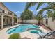 Serene backyard oasis featuring a sparkling pool, spa, lush palm trees, and lounge chairs at 1667 Sabatini Dr, Henderson, NV 89052