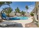 Relaxing backyard retreat featuring a refreshing pool, swaying palm trees, and comfortable lounge seating at 1667 Sabatini Dr, Henderson, NV 89052