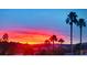 Vibrant sunset scene featuring silhouette of palm trees and colorful sky over neighborhood rooftops at 1667 Sabatini Dr, Henderson, NV 89052