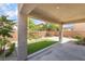 A covered patio overlooks a well-maintained backyard featuring a lawn and landscaped borders at 190 Tall Ruff Dr, Las Vegas, NV 89148