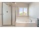Clean bathroom featuring a separate shower and relaxing soaking tub near the window at 190 Tall Ruff Dr, Las Vegas, NV 89148