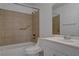 Bathroom featuring tiled shower, grab bar, white sink and toilet, creating a functional and accessible space at 201 Mission Laguna Ln # 104, Las Vegas, NV 89107