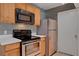Cozy kitchen featuring wood cabinets, stainless steel appliances, and white countertops at 201 Mission Laguna Ln # 104, Las Vegas, NV 89107