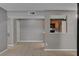 Open living room with neutral walls and tile floors with a view of kitchen at 201 Mission Laguna Ln # 104, Las Vegas, NV 89107