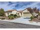 Charming single-story home featuring a tile roof, desert landscaping, and an attached two-car garage at 2148 Shadow Canyon Dr, Henderson, NV 89044