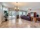 Spacious living room featuring tile floors, a ceiling fan, large windows with curtains, and comfortable leather furniture at 2148 Shadow Canyon Dr, Henderson, NV 89044