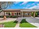 Inviting backyard showcases a covered patio, lush faux grass, and stone walkway at 2175 Sandstone Cliffs Dr, Henderson, NV 89044