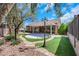 Charming backyard with a covered patio, lush landscaping, and a serene ambiance at 2175 Sandstone Cliffs Dr, Henderson, NV 89044