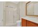 Bathroom featuring a tiled shower, sink with wood cabinet, and gold trimmed mirror at 2175 Sandstone Cliffs Dr, Henderson, NV 89044