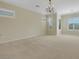 Expansive carpeted bedroom with neutral walls, bright windows with shutters, and decorative chandelier at 2175 Sandstone Cliffs Dr, Henderson, NV 89044