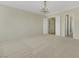 Expansive carpeted bedroom with neutral walls, bright windows with shutters, and decorative chandelier at 2175 Sandstone Cliffs Dr, Henderson, NV 89044