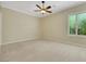 Bright bedroom with carpeted floor, ceiling fan, and a window with plantation shutters at 2175 Sandstone Cliffs Dr, Henderson, NV 89044
