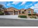 Charming single story home with a terracotta roof, three car garage, and well manicured desert landscaping at 2175 Sandstone Cliffs Dr, Henderson, NV 89044