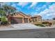 Stylish single story home displaying a terracotta roof, three car garage, and attractive xeriscaping at 2175 Sandstone Cliffs Dr, Henderson, NV 89044