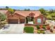 Inviting single story home showcasing a three car garage, terracotta roof, and vibrant front garden at 2175 Sandstone Cliffs Dr, Henderson, NV 89044