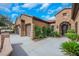 Single story home with terracotta roof, three car garage, and desert landscaping at 2175 Sandstone Cliffs Dr, Henderson, NV 89044