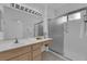 Bathroom with double sinks, shower with glass doors, tile floors, and bright vanity lighting at 2323 Barbers Point Pl, Las Vegas, NV 89134