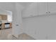 Hallway into kitchen featuring tile floors, white cabinetry and appliances at 2323 Barbers Point Pl, Las Vegas, NV 89134