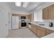 Well-lit kitchen with stainless steel appliances, light wood cabinetry, and white countertops at 2323 Barbers Point Pl, Las Vegas, NV 89134