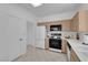 Well-lit kitchen with stainless steel appliances, light wood cabinetry, and white countertops at 2323 Barbers Point Pl, Las Vegas, NV 89134