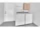 Convenient laundry area with washer, dryer, storage shelves, and a utility door at 2323 Barbers Point Pl, Las Vegas, NV 89134