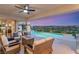 Covered patio with outdoor seating area with a mountain view overlooking a pristine pool and manicured landscape at 2736 Botticelli Dr, Henderson, NV 89052