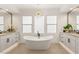 Modern bathroom with soaking tub, dual vanities, and elegant chandelier lighting at 2736 Botticelli Dr, Henderson, NV 89052