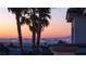 Palm trees frame the cityscape, showcasing the dazzling lights of the city against a colorful sunset sky at 2736 Botticelli Dr, Henderson, NV 89052