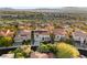 Beautiful two-story home with red tile roof and solar panels in a lush, green neighborhood with mountain views at 2736 Botticelli Dr, Henderson, NV 89052